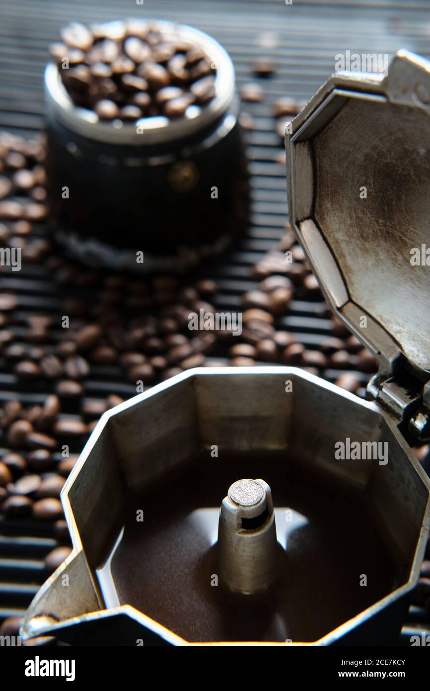 Caffè in caffettiera e chicchi di caffè sul tavolo Foto Stock