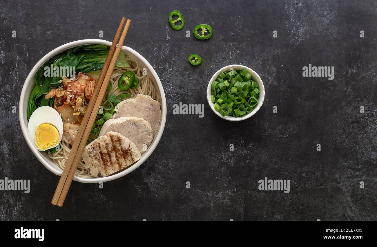 Tagliatelle asiatiche di Miso Ramen con uova, pollo e cavolo di pak Choi in ciotola. Foto Stock