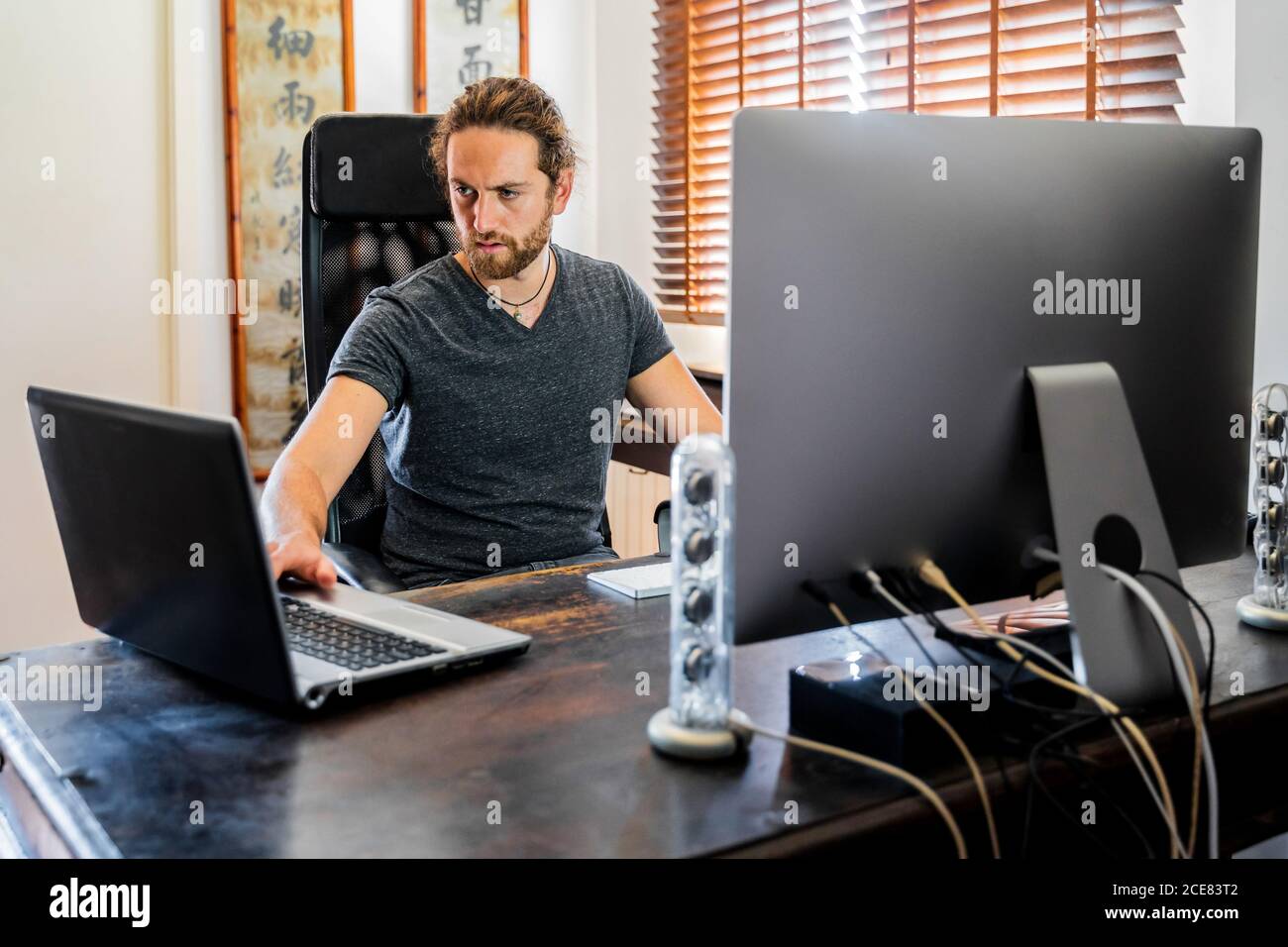 Bell'uomo che lavora al computer desktop a casa Foto stock - Alamy