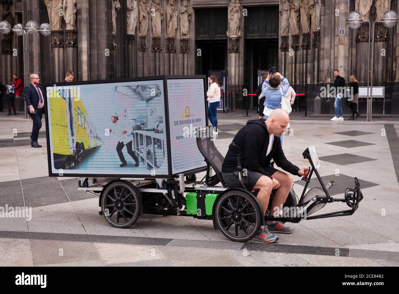 bici elettrica (trike) con schermo LED digitale a 360 gradi per la pubblicità mobile all'aperto di fronte alla cattedrale, Colonia, Germania. Elektrisches Bik Foto Stock