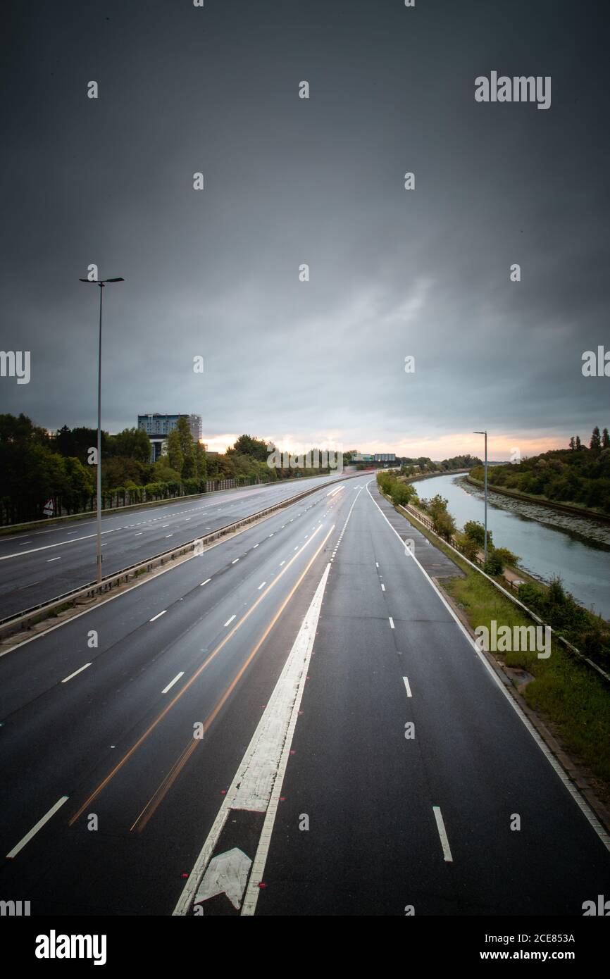 Sentieri leggeri di auto in movimento su un'autostrada inglese con tempo tempestoso in testa Foto Stock