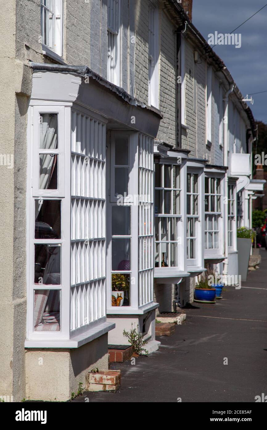 Una fila di case a schiera con finestre a bovindo a Hambledon Hampshire, una fila di tipici cottage rurali terrazzati Foto Stock