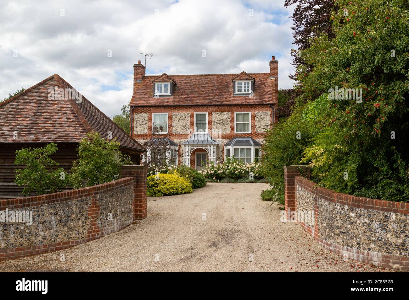 Una grande casa di campagna inglese con un grande vialetto, Hambledon, Hampshire, Regno Unito Foto Stock