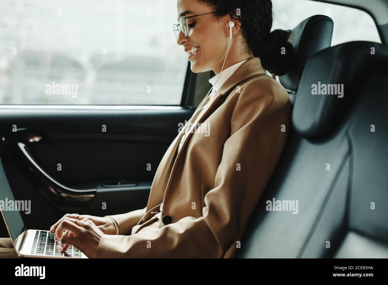 Donna d'affari che sorride felice lavorando all'interno di un'auto di lusso  aziendale