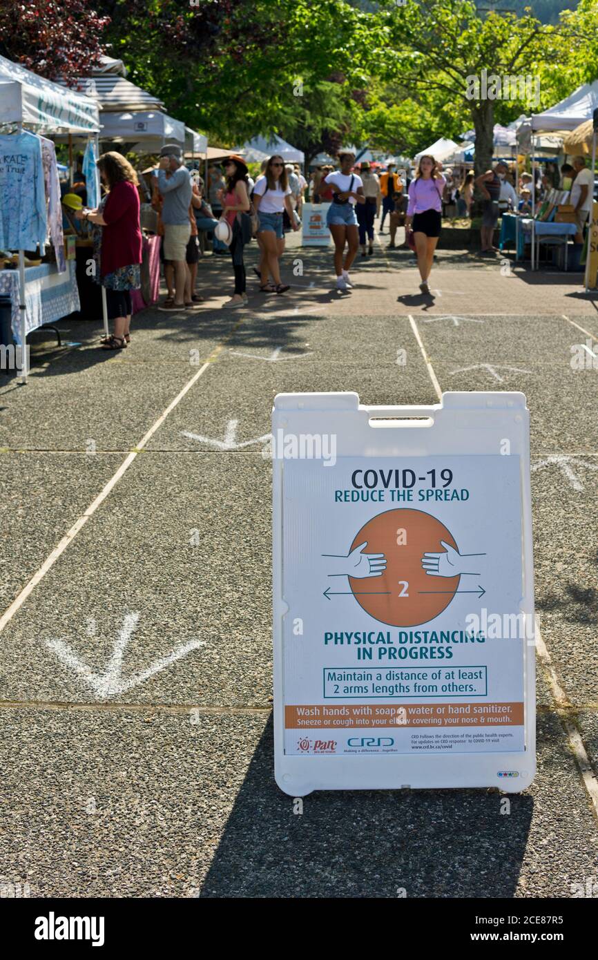 Agosto 2020: Mercato del sabato a Salt Spring Island, British Columbia, cartello che dice alle persone di praticare il distanziamento fisico a causa della pandemia di Covid 19 Foto Stock