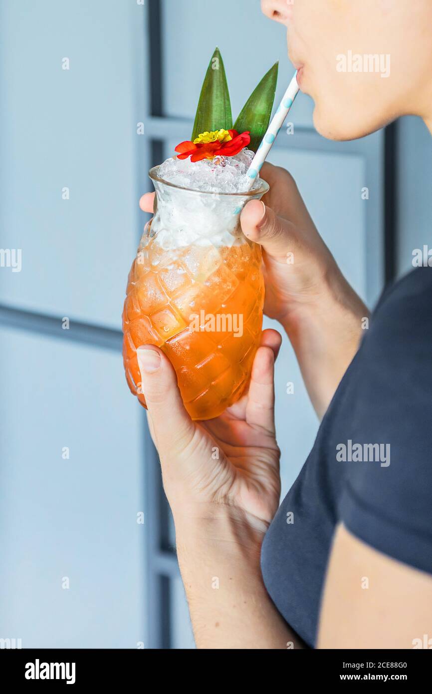 cocktail fresco di presa femminile senza volto con cannuccia di vetro forma di ananas Foto Stock