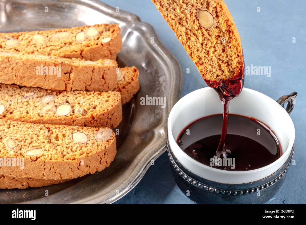 Biscotti, biscotti tradizionali italiani alle mandorle, immersi in una tazza di cioccolata calda Foto Stock