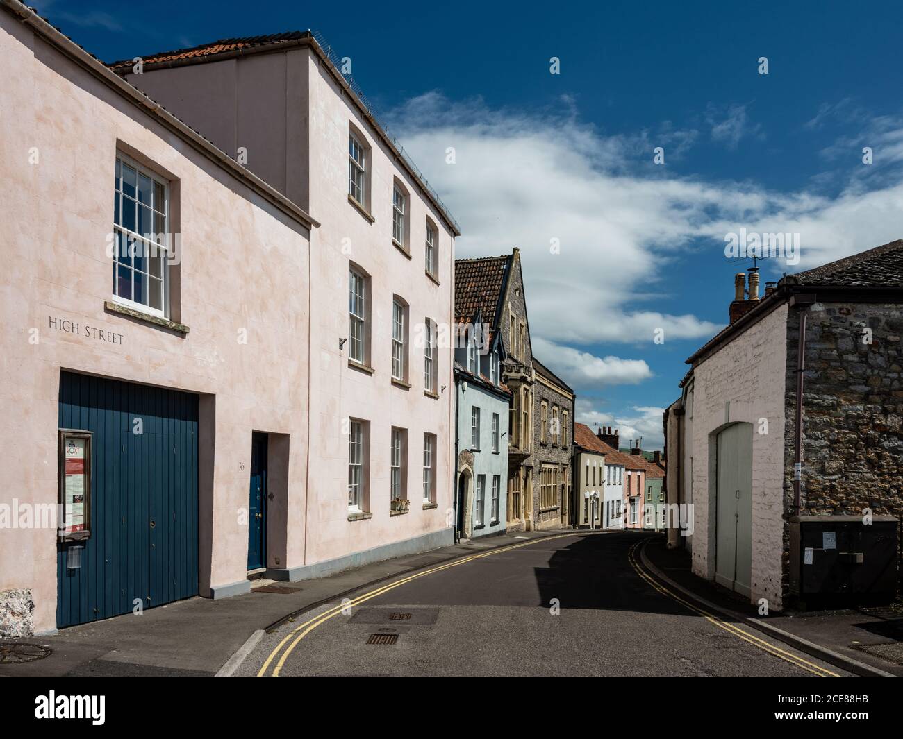 Il sole splende sulle vecchie case tradizionali di High Street ad Axminster, Somerset. Foto Stock