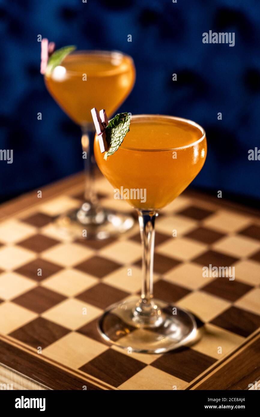 Bicchieri di bevanda alcolica all'arancia con foglia di menta scacchiera al  bar Foto stock - Alamy