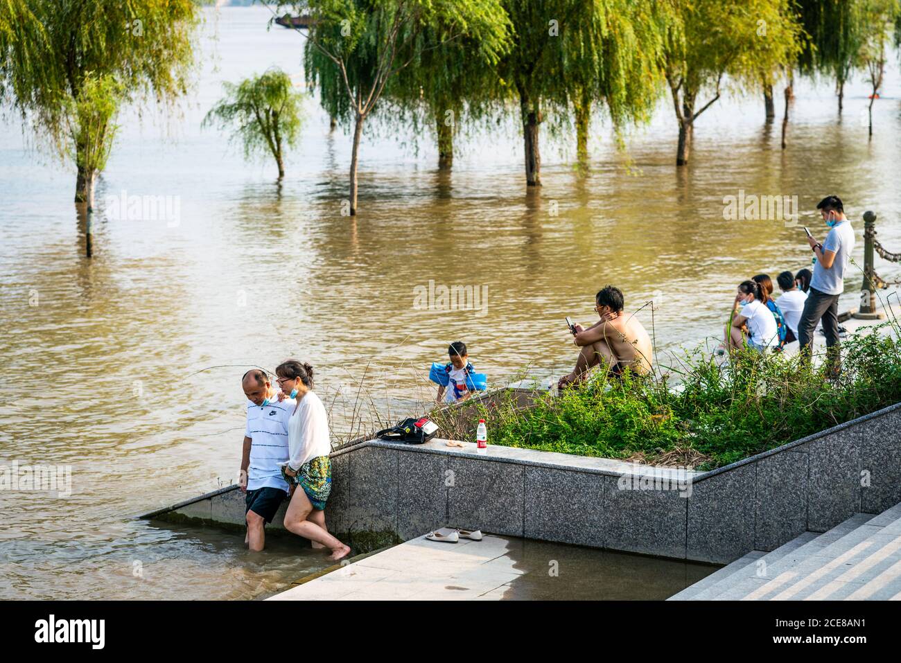 Wuhan Cina , 30 agosto 2020 : i cinesi che godono di caldo sole estate 2020 giorni sul fiume Yangtze inondato rive del fiume in Wuhan Hubei Cina Foto Stock