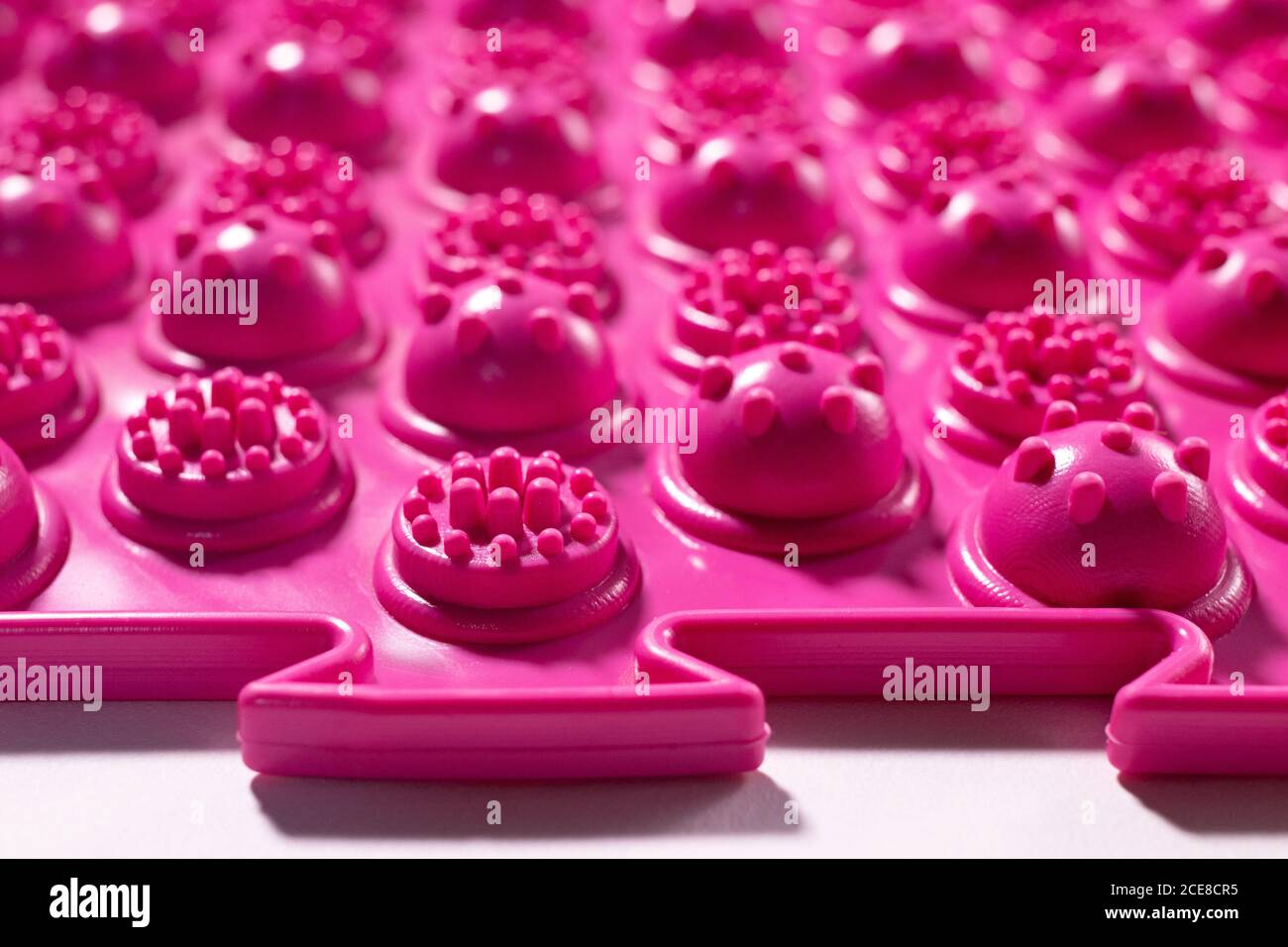 Tappetino ortopedico per agopuntura rosa. Tappetino massaggiante per la prevenzione dei piedi piani in bambini e adulti Foto Stock