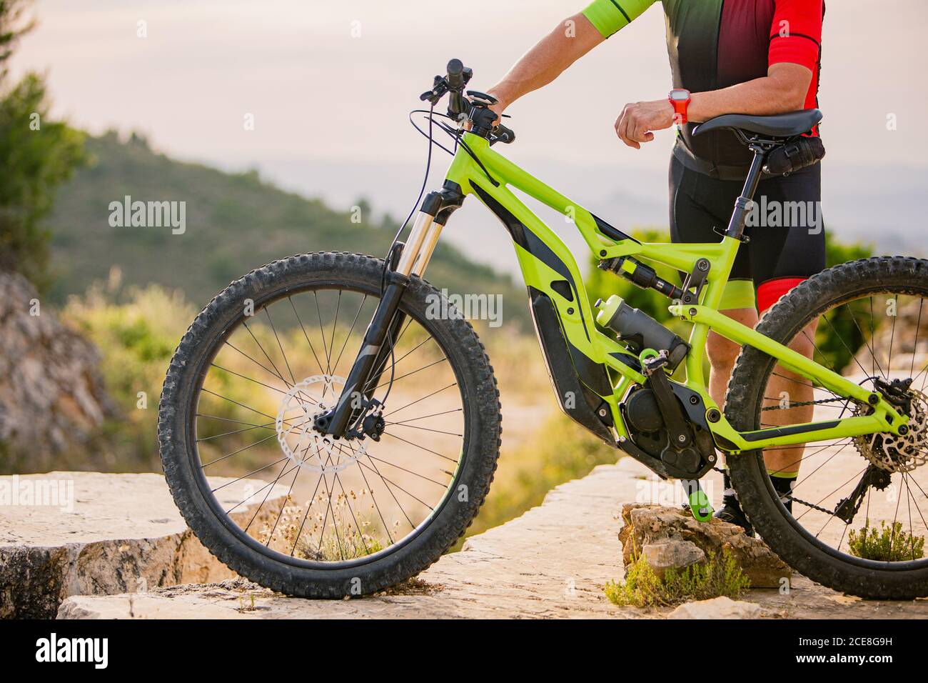 uomo in piedi vicino alla mountain bike nella foresta Foto Stock