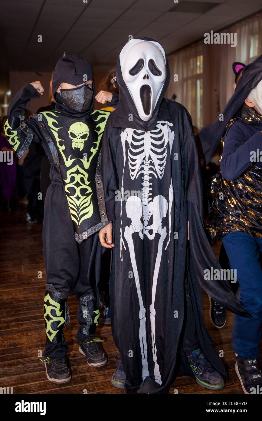 Ucraina, Kiev - 25 ottobre 2019: Bambini adolescenti celebrare Halloween a scuola. Festa in costume. Studenti delle scuole superiori in spaventosi costumi di strega. Ragazzi Foto Stock