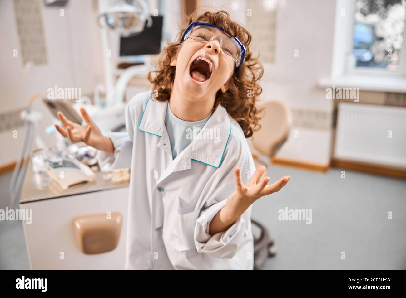 Buon bambino che indossa un camice da laboratorio e occhiali di protezione Foto Stock