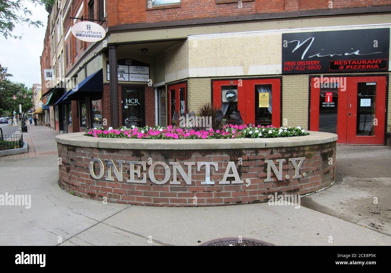'Oneonta, N.Y.' piantatrice segnata piena di fiori accoglie i visitatori nella zona commerciale di Main Street di questa parte settentrionale dello stato di New York. Foto Stock