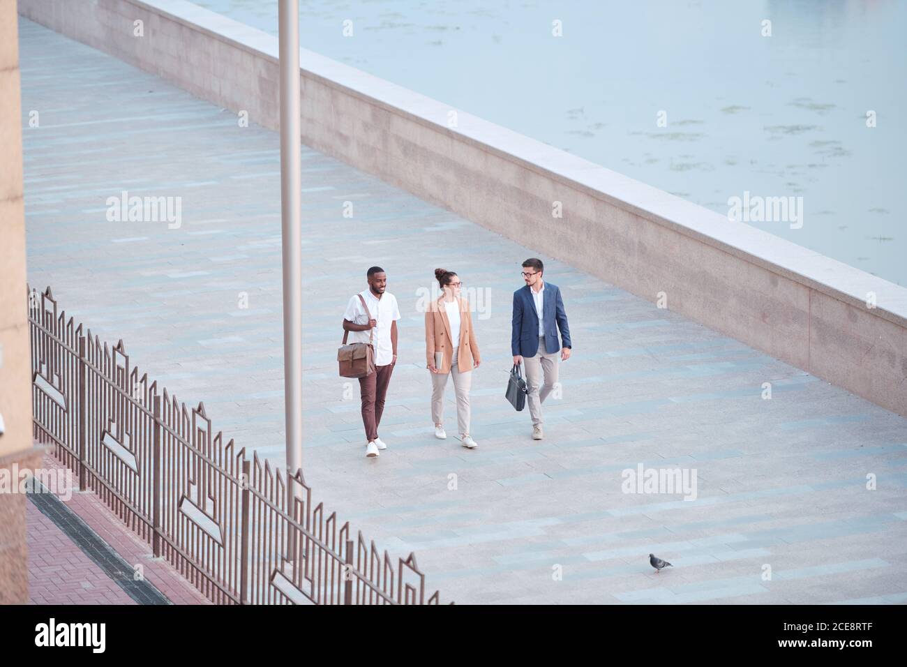 Sopra la vista degli studenti di affari interracial che camminano sull'argine e. discutere di nuovi progetti Foto Stock