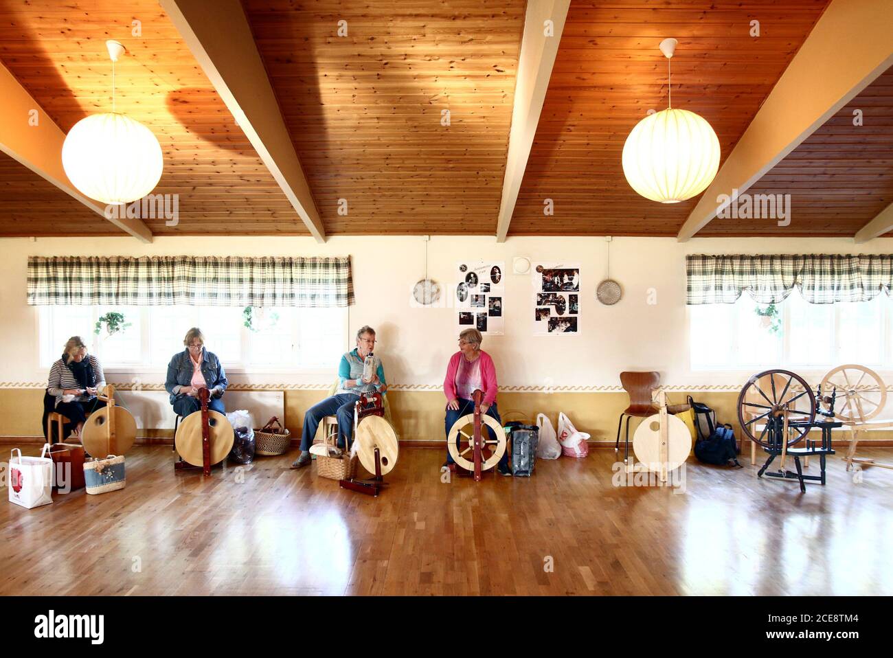 Donne che si incontrano e filatura lana con ruote di filatura. Foto Gippe Gustafsson Foto Stock