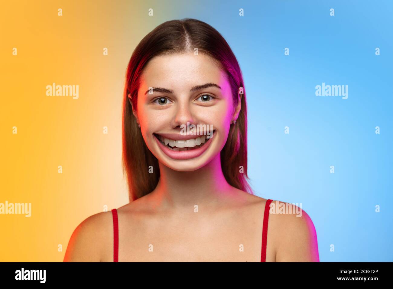 Bellissima. Sorridente ragazza con sorriso surreale enorme e bocca grande sembra scioccato, attratto, meravigliato e isolato stupito su sfondo studio gradiente. CopySpace per l'annuncio. Emozioni umane, marketing, offerta. Foto Stock