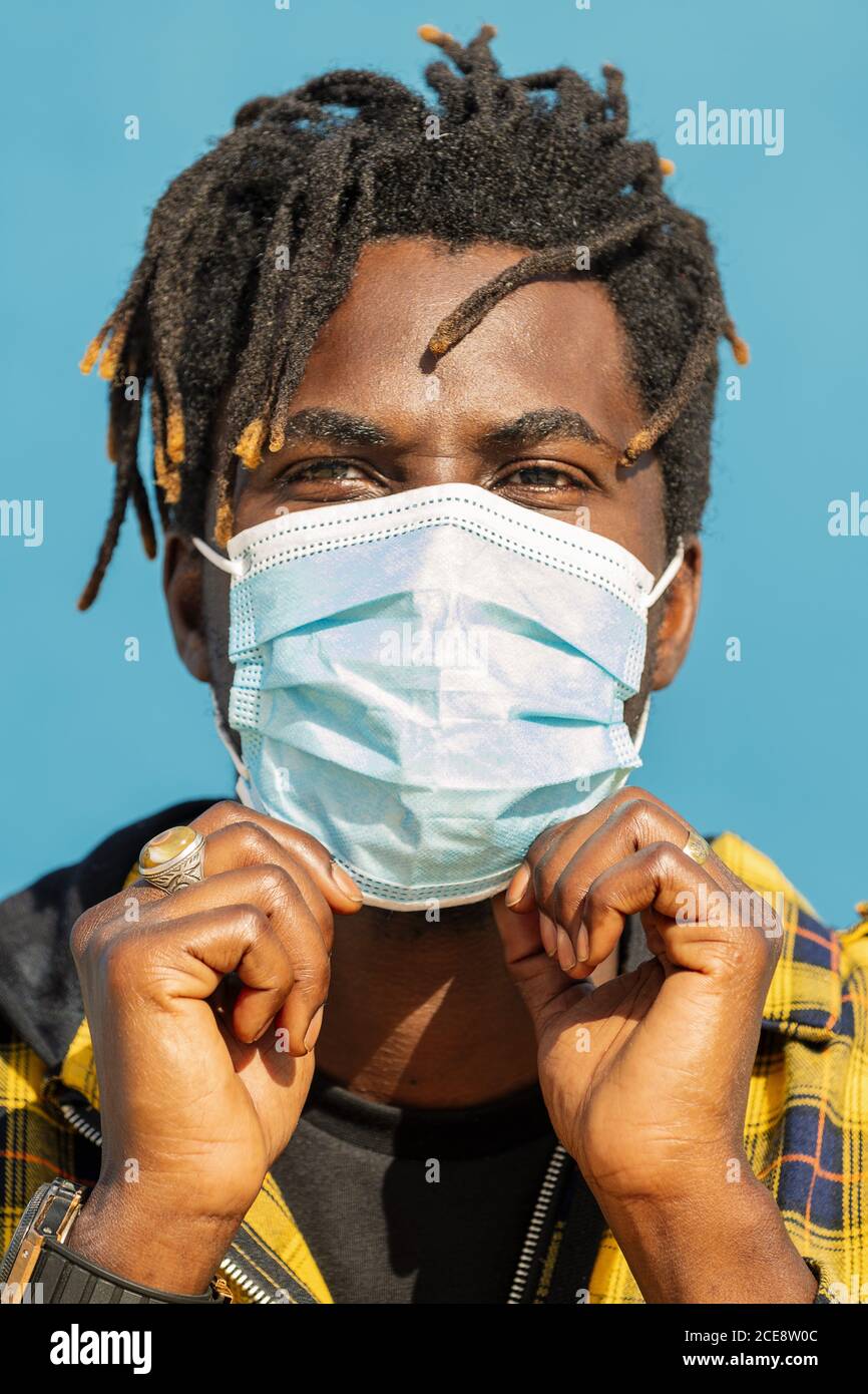 closeup verticale di un giovane e attraente uomo nero che indossa una maschera protettiva, stile di vita concetto e protezione covid Foto Stock