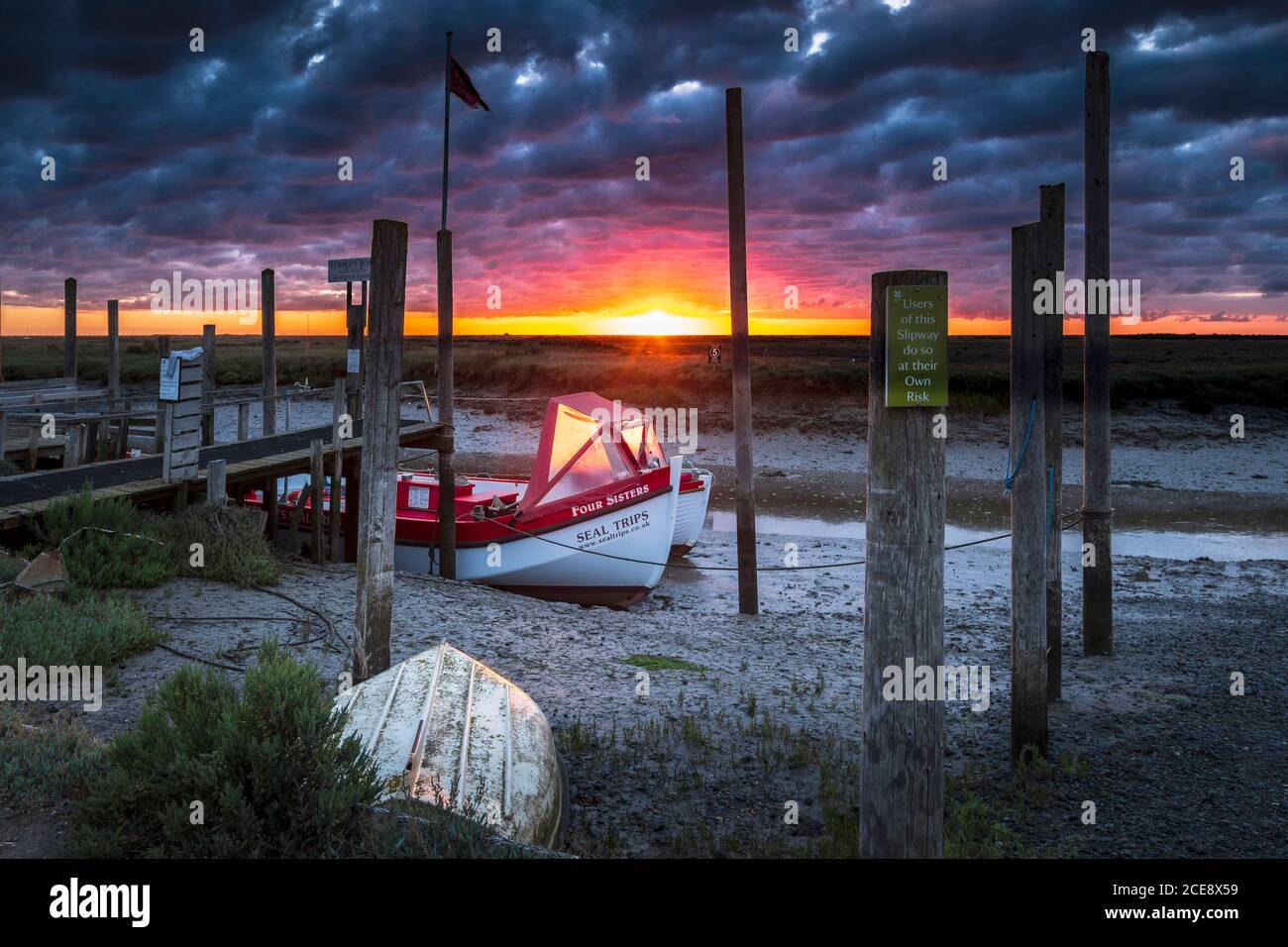 Il sole illumina una barca sulla costa del Norfolk. Foto Stock