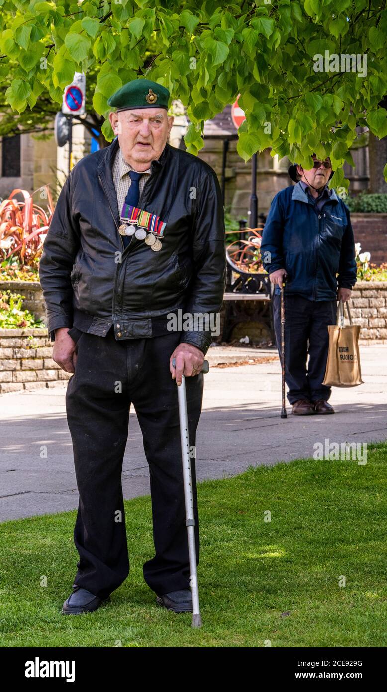 Un veterano osserva due minuti di silenzio per onorare i caduti di fronte al War Memorial nel centro di Harrogate. Foto Stock