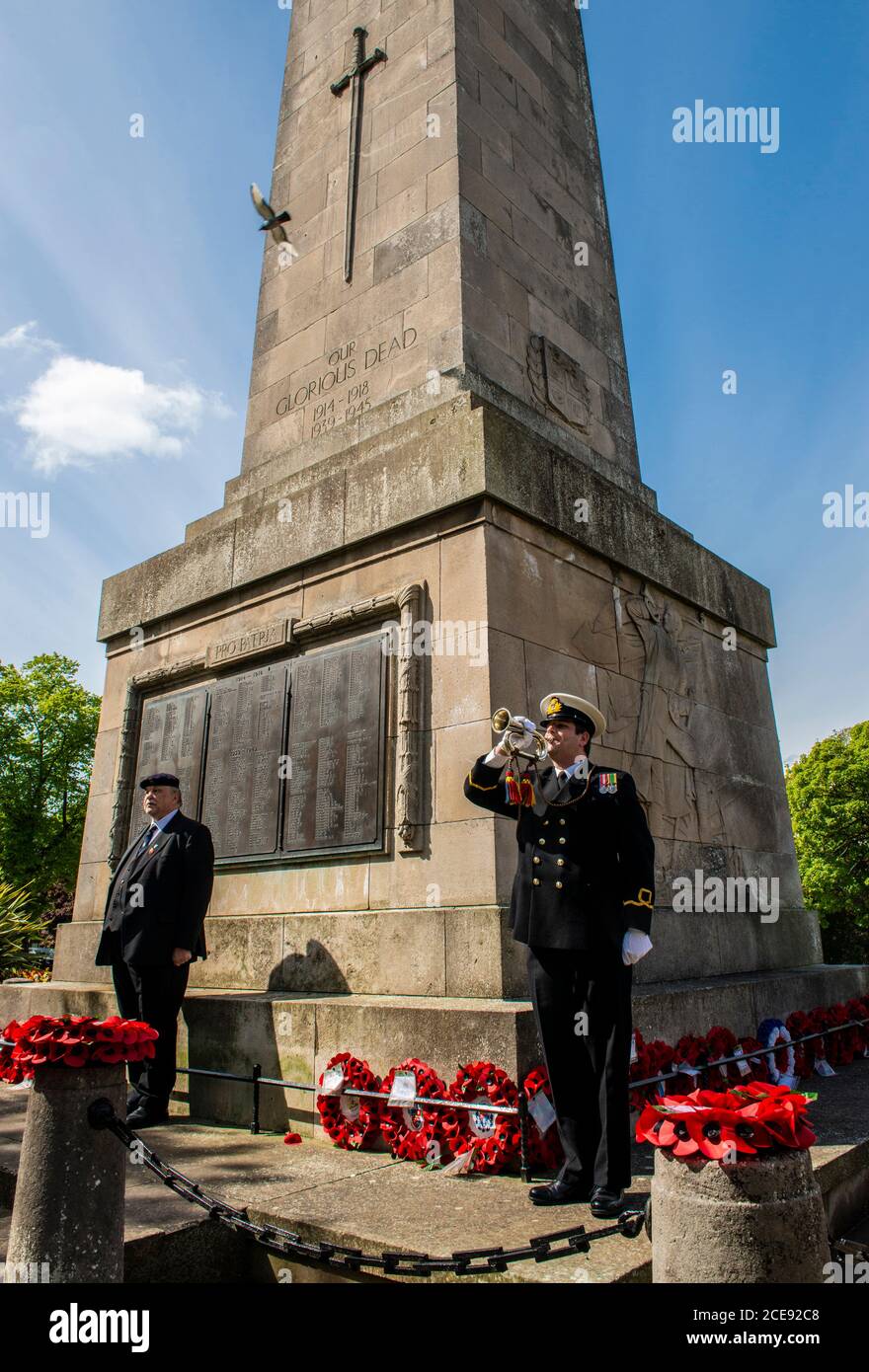 Un trombettista segna l'inizio di due minuti di silenzio per onorare i caduti di fronte al War Memorial nel centro di Harrogate. Foto Stock