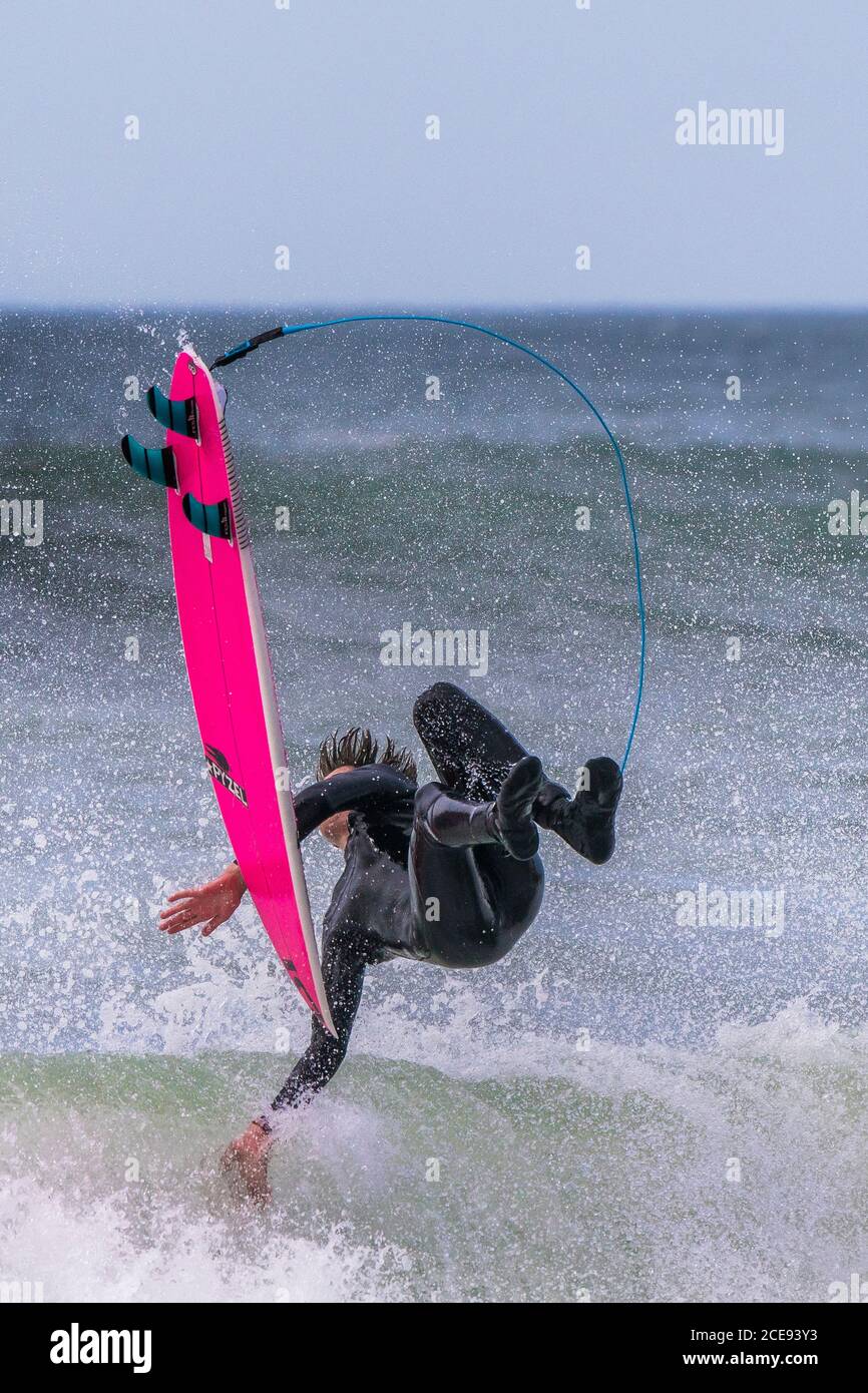 Azione spettacolare mentre un surfista maschile si svanisce su un'onda a Fistral a Newquay in Cornovaglia. Foto Stock