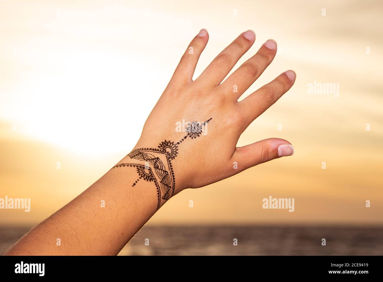 tatuaggio hennè dipinto sulla mano al tramonto Foto Stock