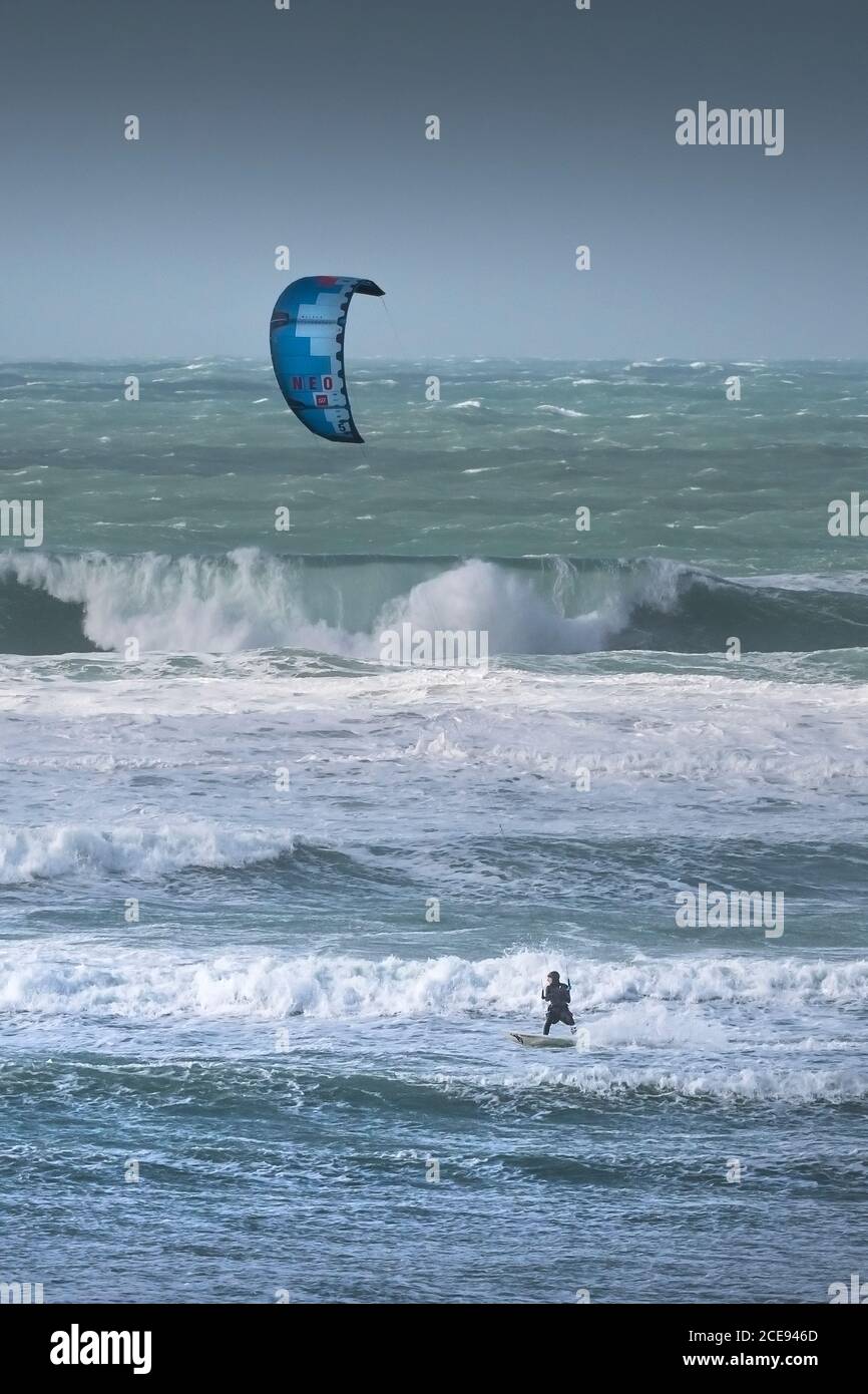 Un semplice kite surfer boarder che gode del forte vento portato da Storm Jorge a Fistral a Newquay in Cornovaglia. Foto Stock