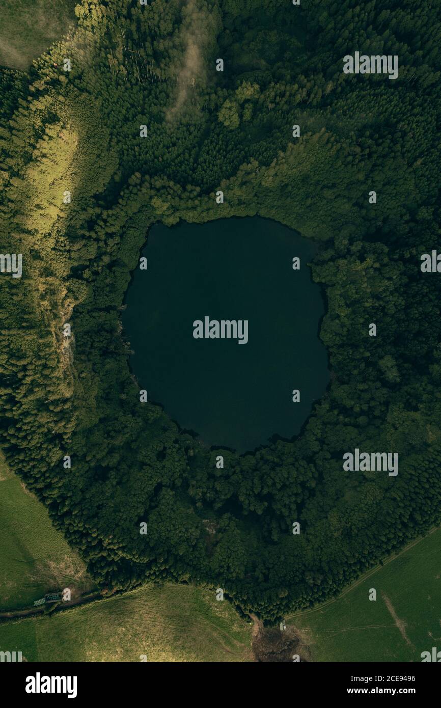 Vista aerea del piccolo e bellissimo lago cratere circondato dal verde piante Foto Stock