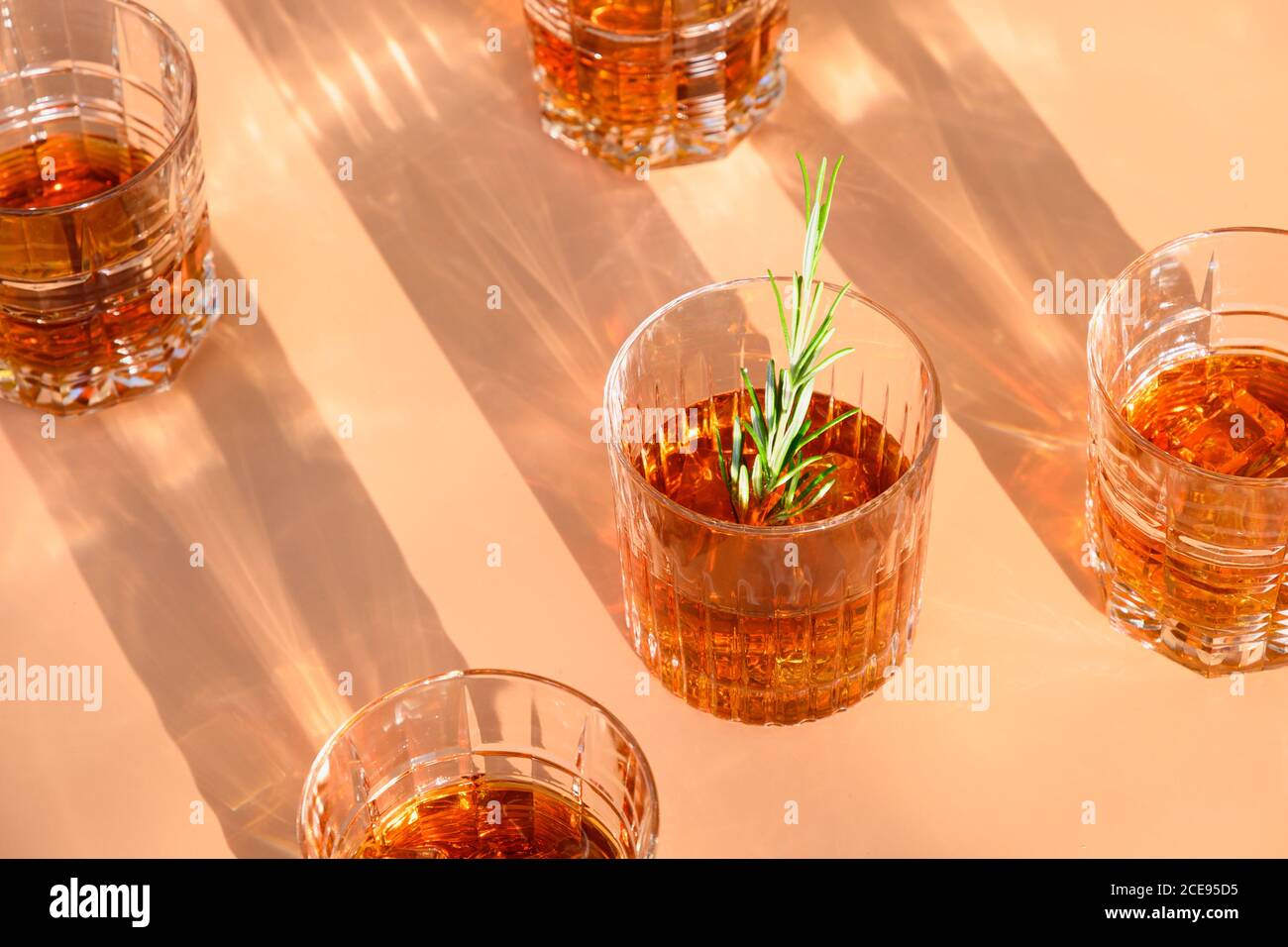 Bicchieri di whisky con rosmarino su beige. Foto Stock