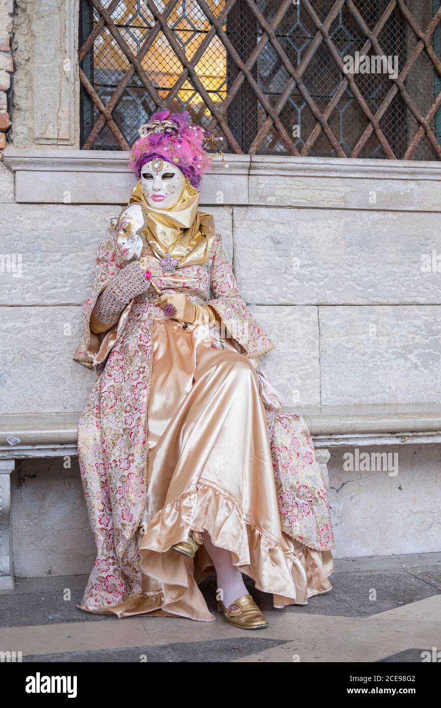 Una donna seduta in costume da carnevale a Venezia. Foto Stock