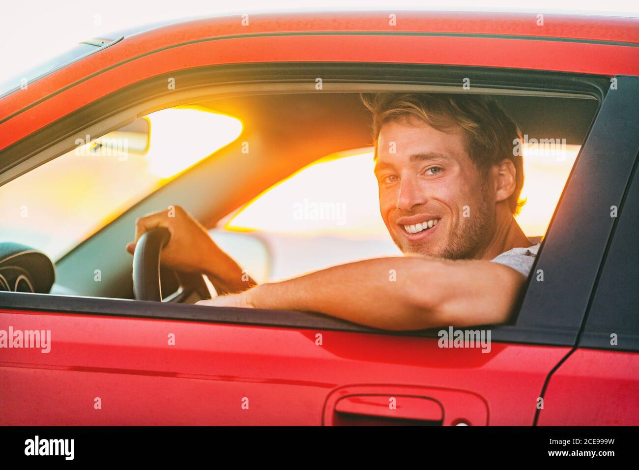 Viaggio su strada estate viaggio vacanza uomo guida auto elettrica sportscar . Conducente maschile al finestrino dietro la ruota del nuovo veicolo ecologico a energia verde Foto Stock