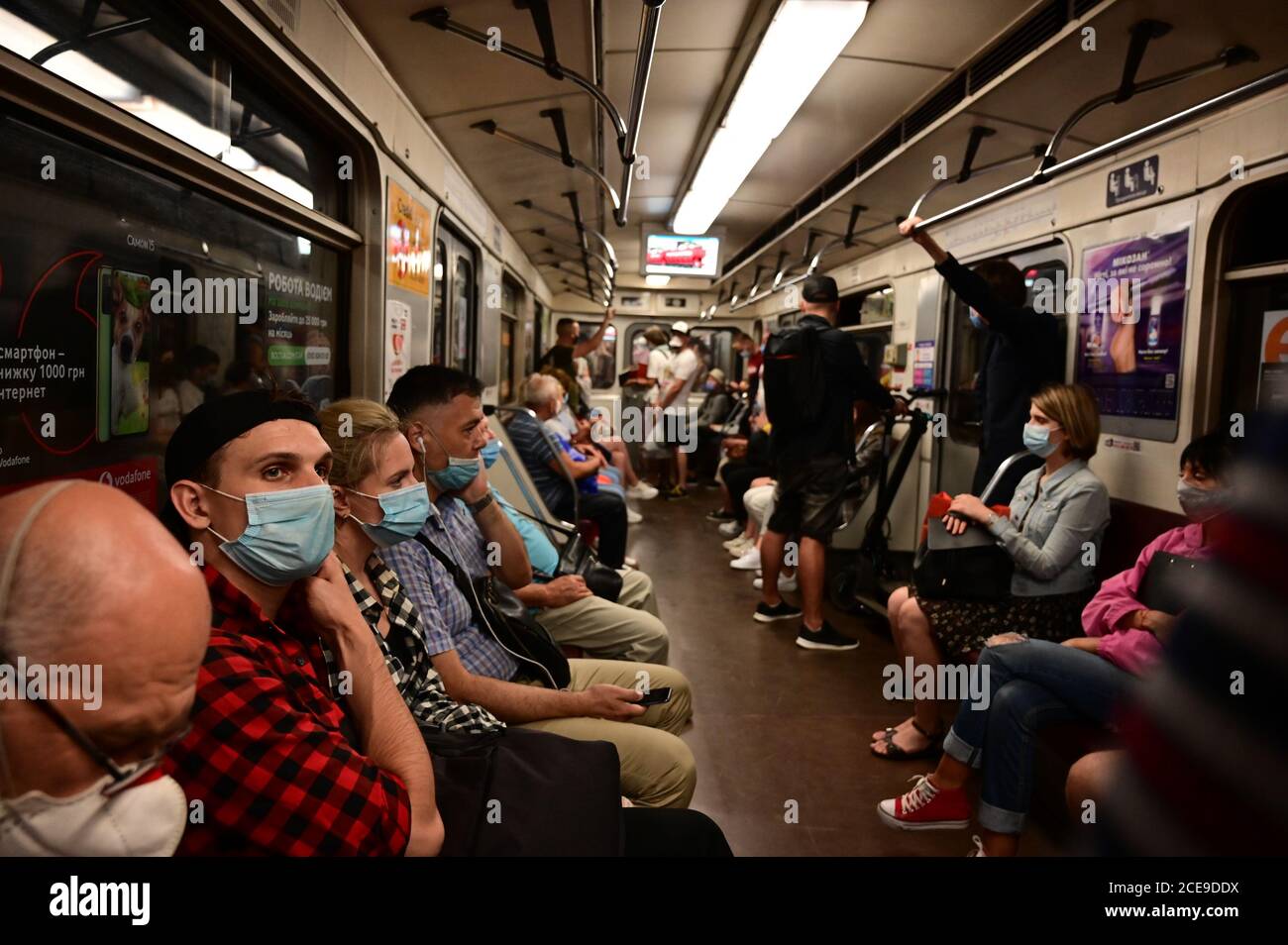 I passeggeri dei treni della metropolitana viaggiano in maschere di protezione in conformità con i requisiti delle misure sanitarie. Foto Stock