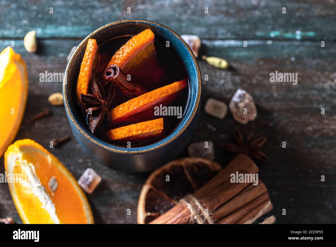 Vino rosso bollito natalizio con spezie e frutta su un tavolo rustico in legno. Foto Stock