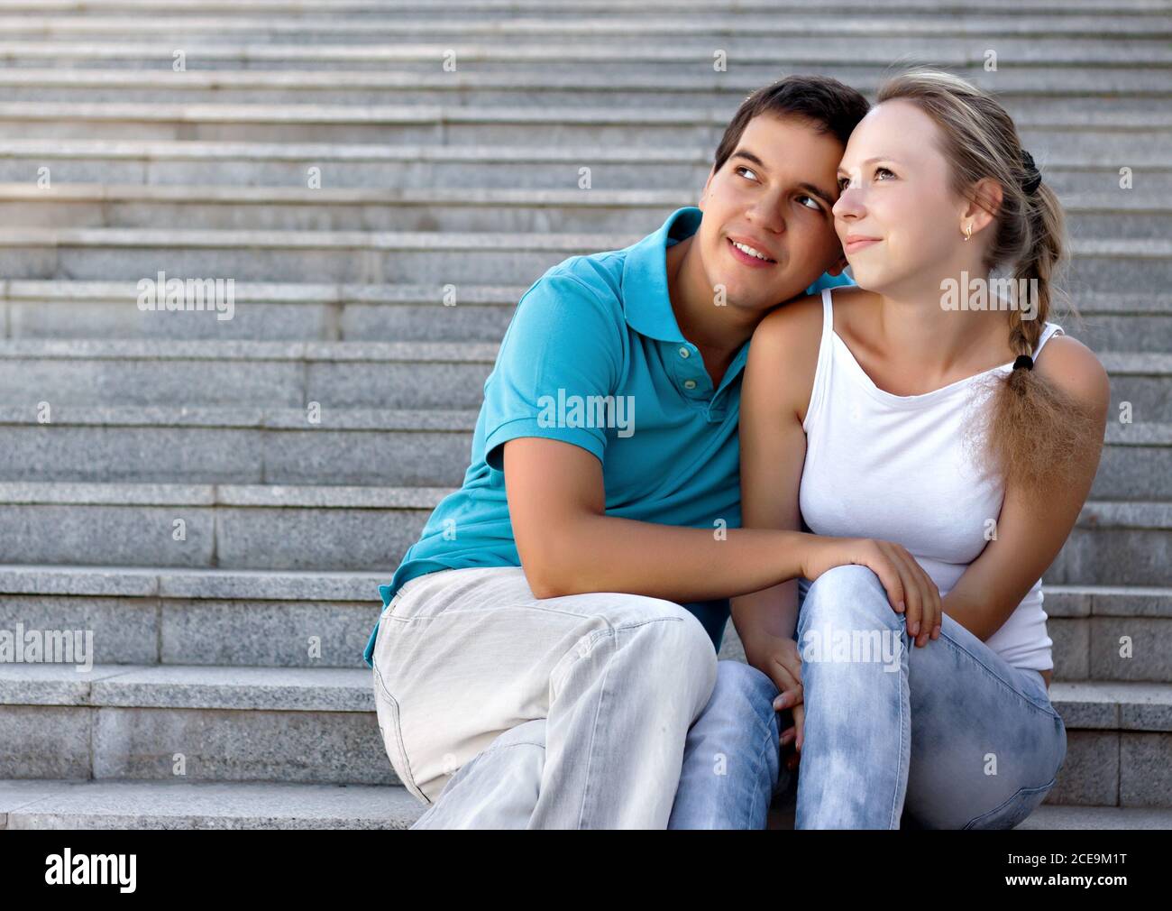 coppia seduto sulle scale e guardando nel cielo Foto Stock
