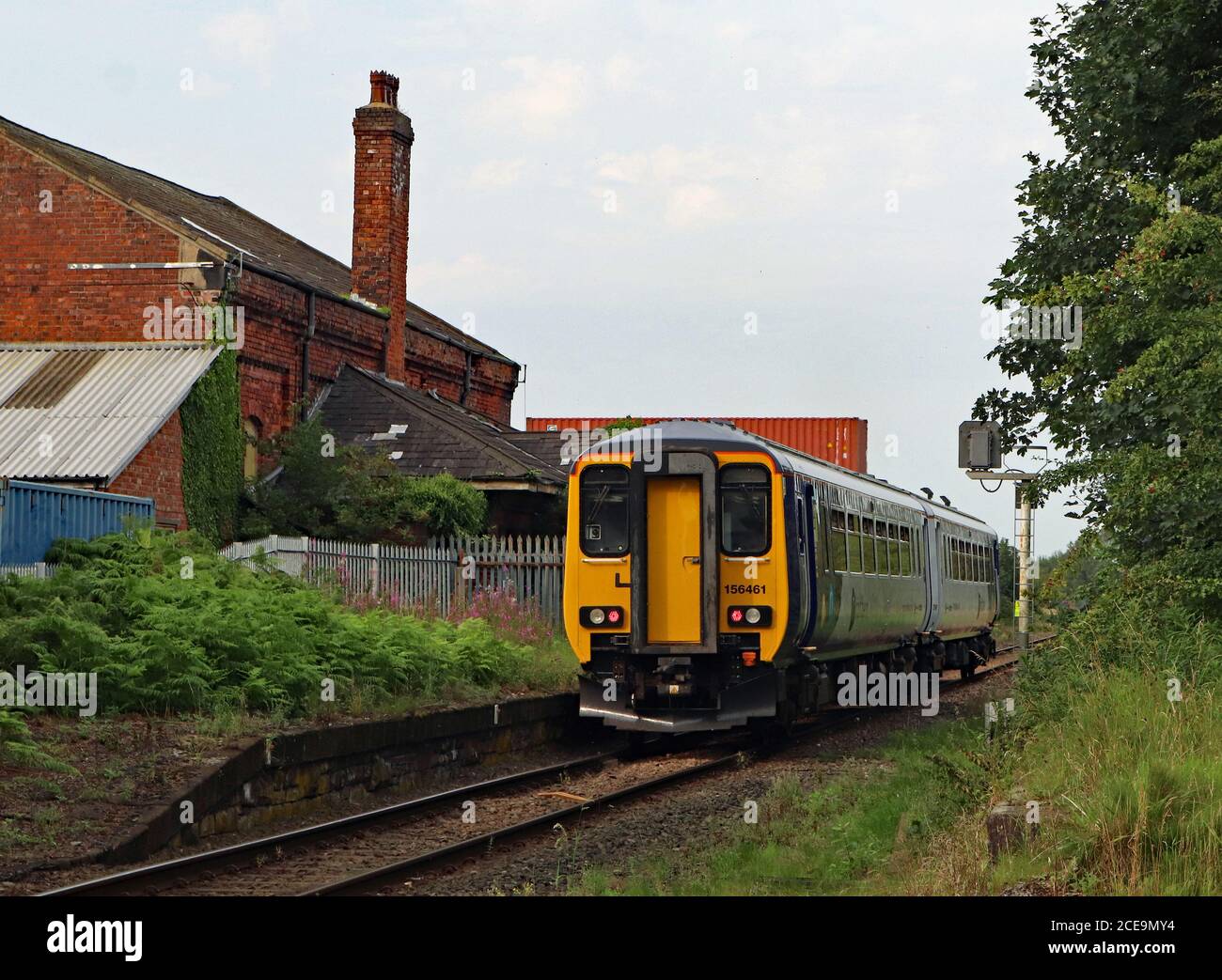 Un treno Nord passa attraverso la stazione chiusa, Midge Hall vicino a Leyland in Lancashire potrebbe questa stazione essere riaperta per invertire un taglio Beeching? Foto Stock