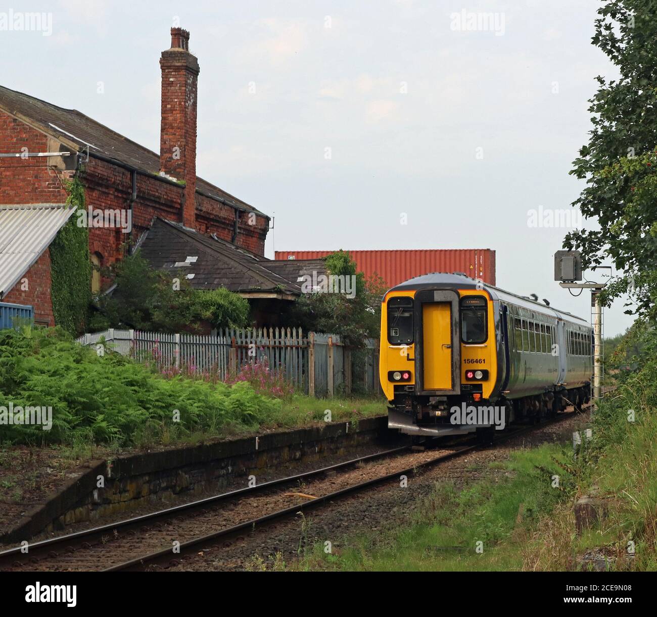 Un treno Nord passa attraverso la stazione chiusa, Midge Hall vicino a Leyland in Lancashire potrebbe questa stazione essere riaperta per invertire un taglio Beeching? Foto Stock