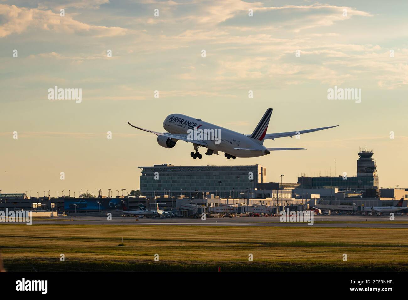 Montreal, Quebec / Canada - 06/21-2020 : un Air France 787-9 che prende da CYUL, Montreals International Airport al tramonto. Con il terminale e l'aeroporto Foto Stock