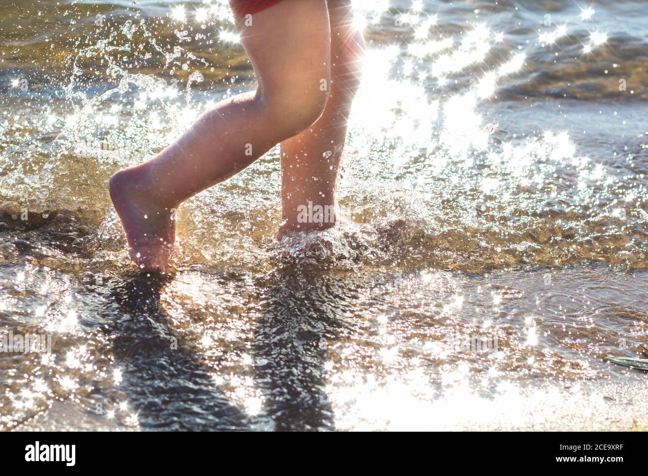 Piedi, e un sacco di gocce d'acqua che spruzzano sullo sfondo della spiaggia Foto Stock