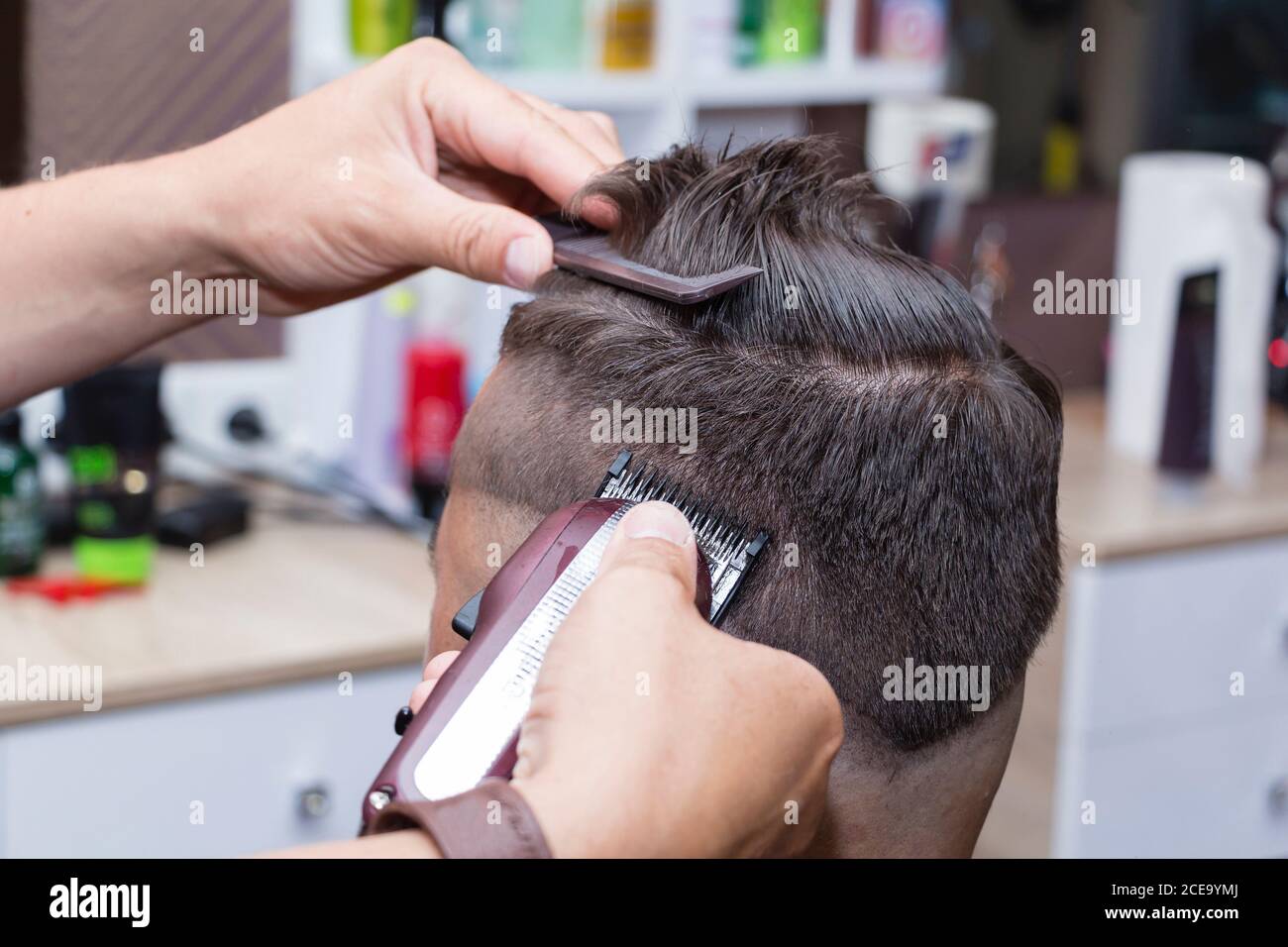 Capelli da uomo styling e cura dei capelli con l'aiuto di forbici e regolacapelli nel salone di parrucchiere. Foto Stock