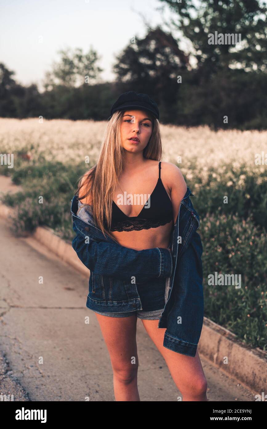 Giovane donna in reggiseno nero che soggiorna nella natura Foto Stock