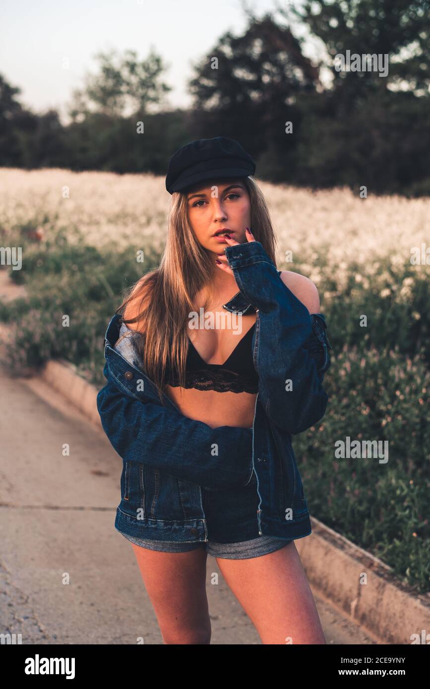 Giovane donna in reggiseno nero che soggiorna nella natura Foto Stock