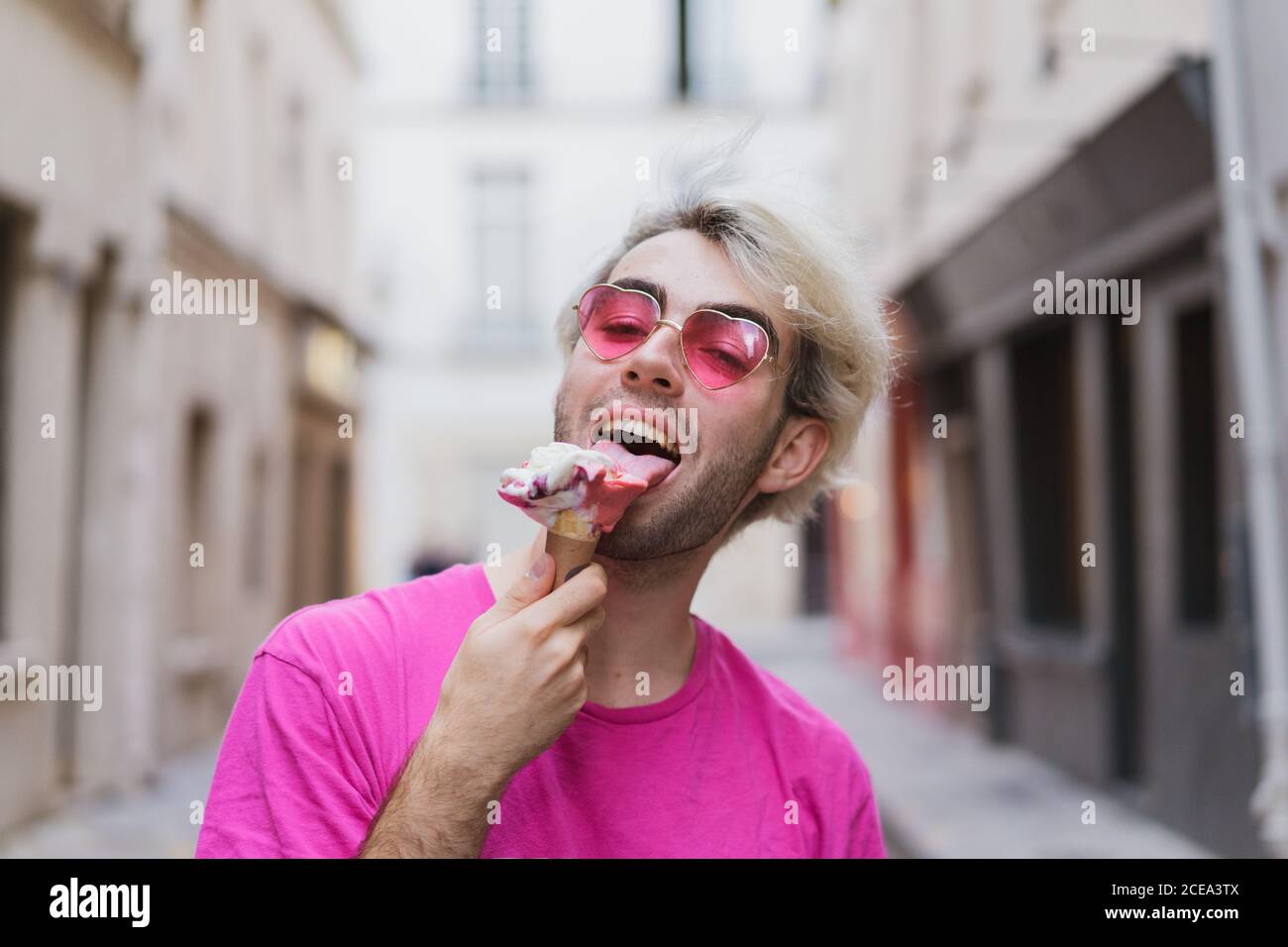 Uomo alla moda che mangia gelato sulla strada Foto Stock