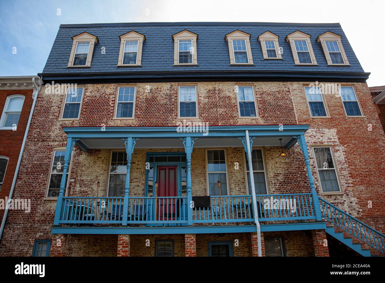 Una grande casa d'epoca con esterni in mattoni scoloriti situata nel quartiere storico di Annapolis, Maryland. L'edificio ha po di legno blu Foto Stock