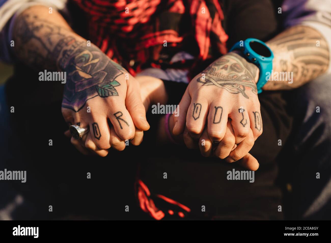 Ritagliare le mani dell uomo di tatuaggi e con anello e guardare tenendo le  mani della signora con sciarpa rossa in tempo soleggiato Foto stock - Alamy