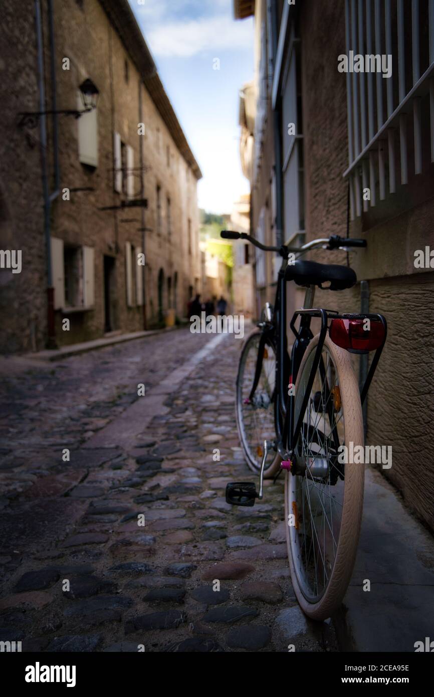 Tiro verticale di una bicicletta parcheggiata nella strada stretta Foto Stock