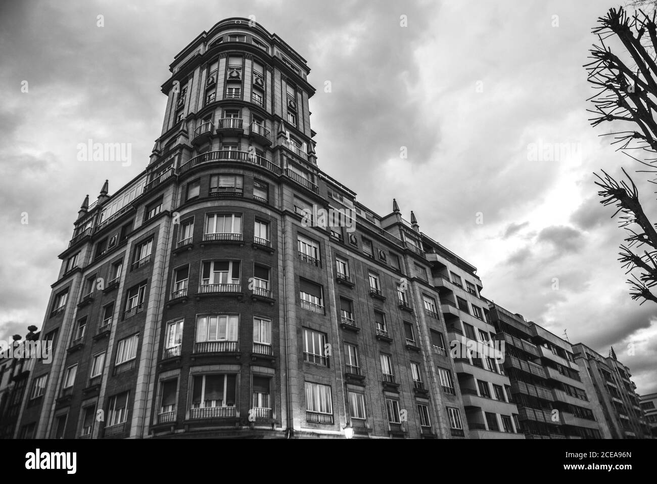 In bianco e nero di maestose vecchio edificio con facciata ornamentali sotto il cielo nuvoloso, Asturias Foto Stock