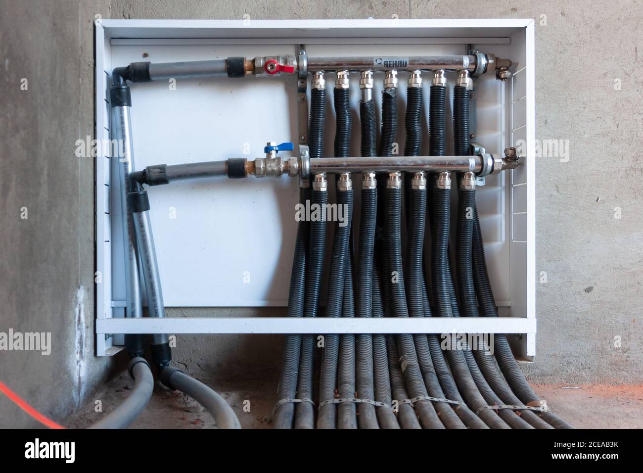 Il collettore di tubazioni Tubazioni del sistema per la casa di distribuzione di acqua, valvole di controllo home acqua tubo, close-up mano umana di apertura della valvola. Foto Stock