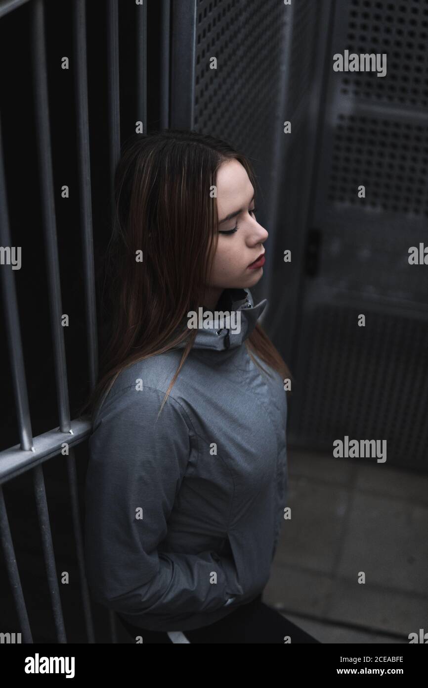 Donna affascinante in cappotto e leggini in piedi su gradini Foto Stock